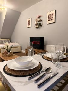 a dining room table with plates and glasses on it at Studio Aurelia - Oldham city centre in Oldham +9 photos