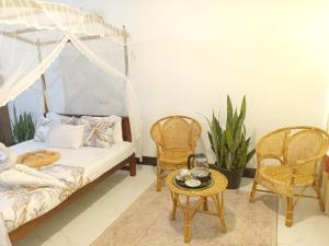 a bedroom with a bed and two chairs and a table at The wave Dickwella in Dickwella