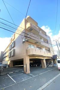 a building with bikes parked in a parking lot at メープル桑園駅202 in Sapporo