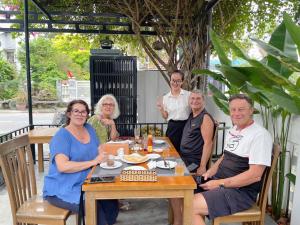 a group of people sitting around a table at Sunora Villa Hoi An in Hoi An