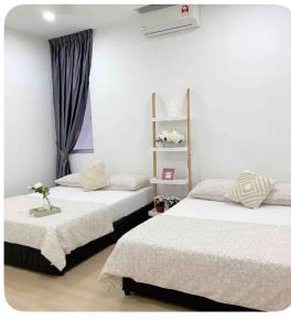 a bedroom with two beds and a window at daisy apartment taiping in Taiping