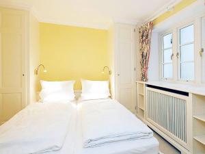a bedroom with two white beds and a window at Heidehaus in Kampen
