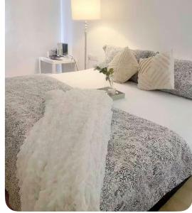 a bed with a white blanket on top of it at daisy apartment taiping in Taiping