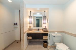 a bathroom with a sink and a toilet and a mirror at Centara Kata Resort Phuket in Kata Beach