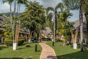 a brick path through a park with palm trees at Centara Kata Resort Phuket in Kata Beach +82 photos