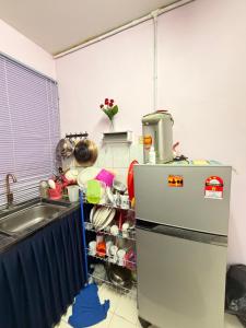 a kitchen with a refrigerator freezer next to a sink at Homestay Arich in Permatang Pauh