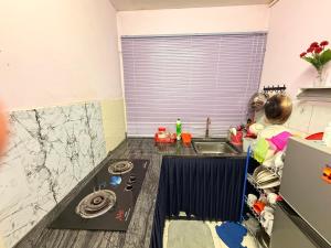 a kitchen with a sink and a counter top at Homestay Arich in Permatang Pauh