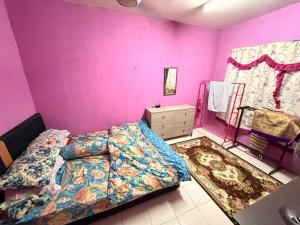 a bedroom with a bed and a purple wall at Homestay Arich in Permatang Pauh