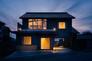 a house with lights on the front of it at Bed and Craft in Nanto