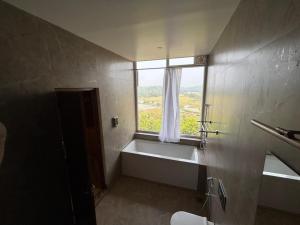 a bathroom with a bath tub and a window at Hill View Resort - Kannur in Pālayangadi +25 photos