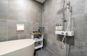 a bathroom with a bath tub and a shower at Daejeon Yuseong MAC Hotel in Yusŏng