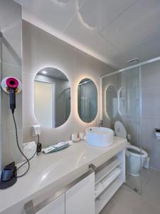a white bathroom with a sink and mirrors at Mr. Slow in Sokcho +13 photos