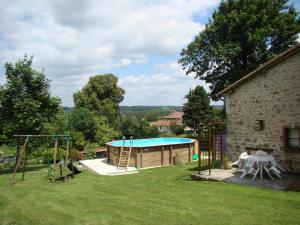 a backyard with a swimming pool and a house at Le bourg in Vaulry