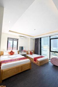 a hotel room with two beds and a window at Harmony Hotel in Hanoi