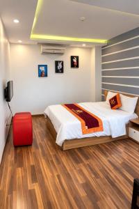 a bedroom with a bed and a red suitcase at Harmony Hotel in Hanoi +59 photos
