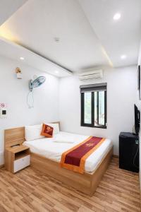 a bedroom with a bed and a window at Harmony Hotel in Hanoi