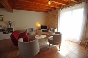 a living room with chairs and a couch and a tv at Le borland in Nantiat