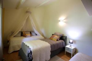 a bedroom with two beds and a canopy at Le borland in Nantiat