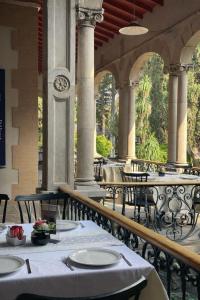 an outdoor restaurant with tables and chairs and columns at Hotel Express Quinta Soledad in Mexico City