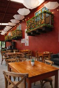 a restaurant with wooden tables and chairs and a red wall at Hotel Express Quinta Soledad in Mexico City +21 photos