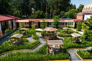 a garden with tables and umbrellas in a building at Hotel Express Quinta Soledad in Mexico City