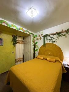 a bedroom with a yellow bed in a room at Casa los Arcos Oaxaca in Oaxaca City