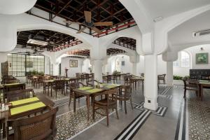 a restaurant with tables and chairs in a room at Paul Chabot Hotel in Hai Phong