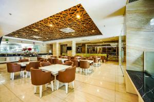 a restaurant with tables and chairs and a bar at Sunerra Express Grand Viveana Bandung in Bandung