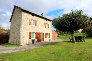 a large brick building with a tree next to it at Négrignas in Augne
