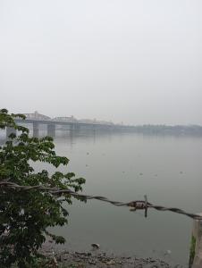 a river with a bridge in the background at Stay on Ganges near Dakshineswar in Howrah