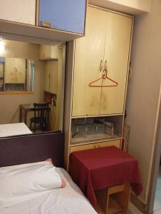 a room with a bed and a table and a cupboard at Stay on Ganges near Dakshineswar in Howrah