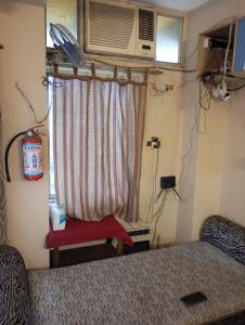 a bedroom with a bed and a window with a microwave at Stay on Ganges near Dakshineswar in Howrah