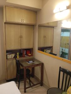 a small kitchen with a table and cabinets at Stay on Ganges near Dakshineswar in Howrah