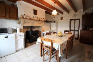 a kitchen with a table with chairs and a stove at Négrignas in Augne +13 photos