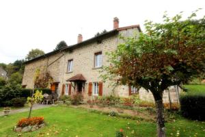 an old stone house with a garden in front of it at Négrignas in Augne