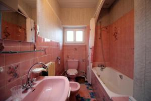 a bathroom with a sink and a toilet and a tub at Négrignas in Augne