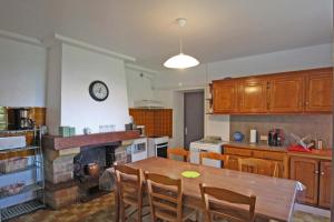 a kitchen with a table and a clock on the wall at Serre in Augne