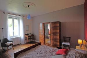 a bedroom with a bed and a cabinet and a window at Serre in Augne