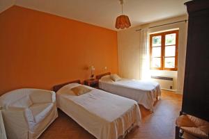 ein Zimmer mit zwei Betten, einem Stuhl und einem Fenster in der Unterkunft Vichez in Beaumont