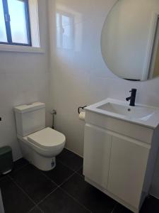 a bathroom with a white toilet and a sink at Heritage City Motor Inn in Broken Hill