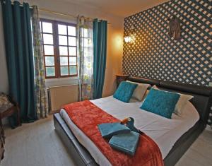 a bedroom with a bed with two towels on it at Villa du lac in Bujaleuf
