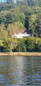 a house on the shore of a body of water at Villa du lac in Bujaleuf