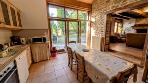 a kitchen with a table and a large window at Les landes in Champnétery
