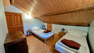 a bedroom with two beds and a wooden ceiling at Les landes in Champnétery