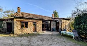 a stone house with a bench in front of it at Les landes in Champnétery