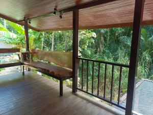 a wooden porch with a bench on a balcony at Than Khao Nature Resort and Homestay - Krabi Noi in Krabi