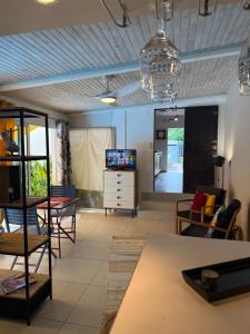 a living room with a table and chairs and a television at Ti Coin Les Coraux in La Saline les Bains