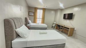 a hotel room with a bed and a television at LTG Grand Hotel Cebu in Cebu City
