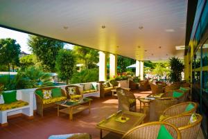 a patio with chairs and tables on a patio at Hotel Concordia 3S in Bibione