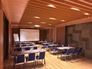 a conference room with tables and chairs and a projection screen at Anumana De Suite in Ubud +91 photos